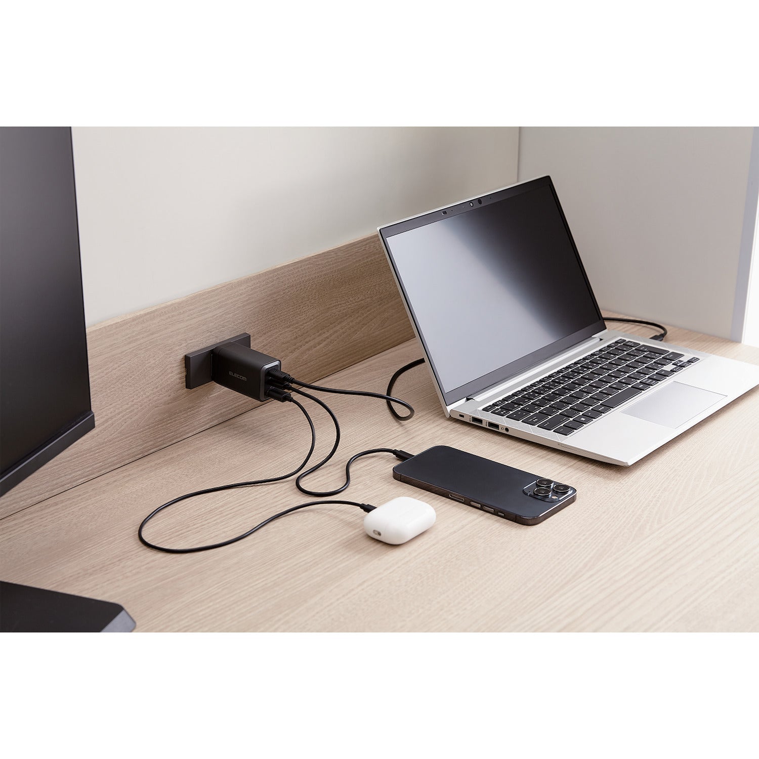 compact wall charger shown charging airpods, iphone, and laptop with max output of 65 watts
