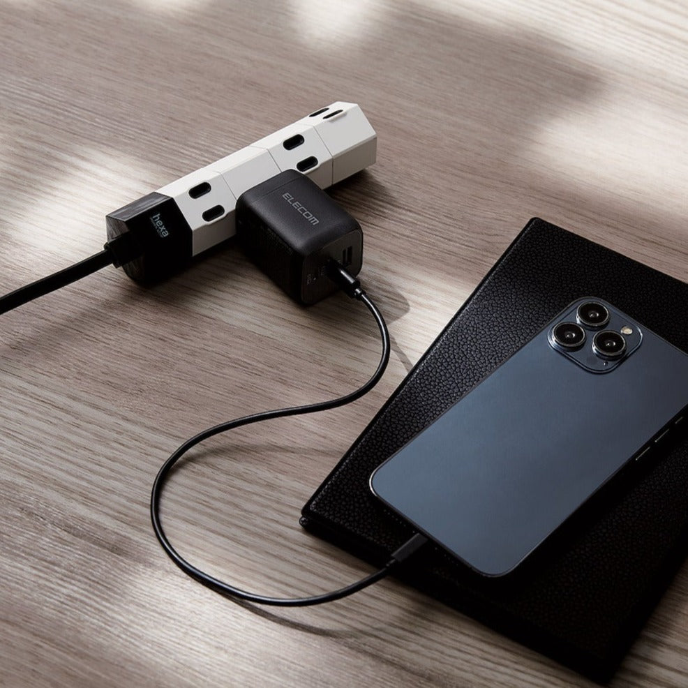 Black Compact Charger GaNII 65W hand plugged into a smartphone | Elecom ultra-high output device charger