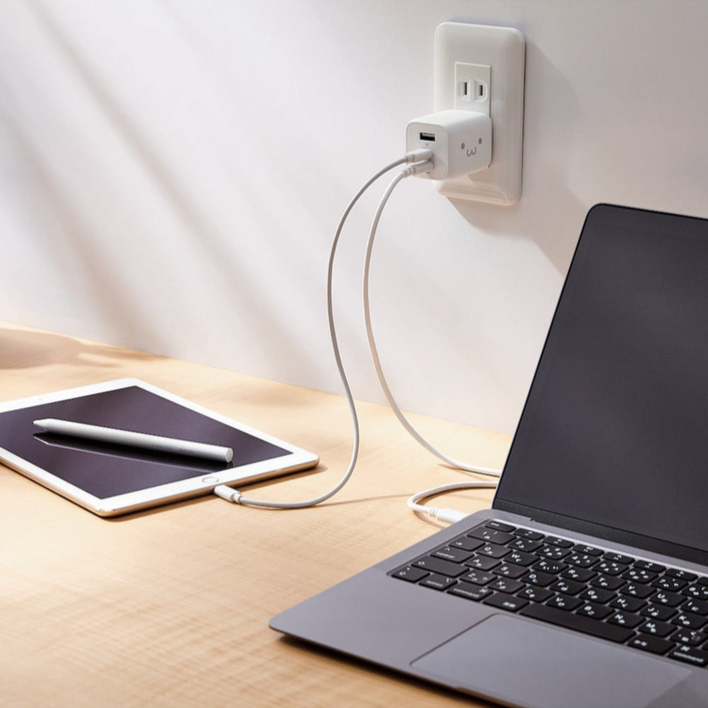 Black Compact Charger GaNII 65W hand plugged into a smartphone and tablet | Elecom ultra-high output device charger