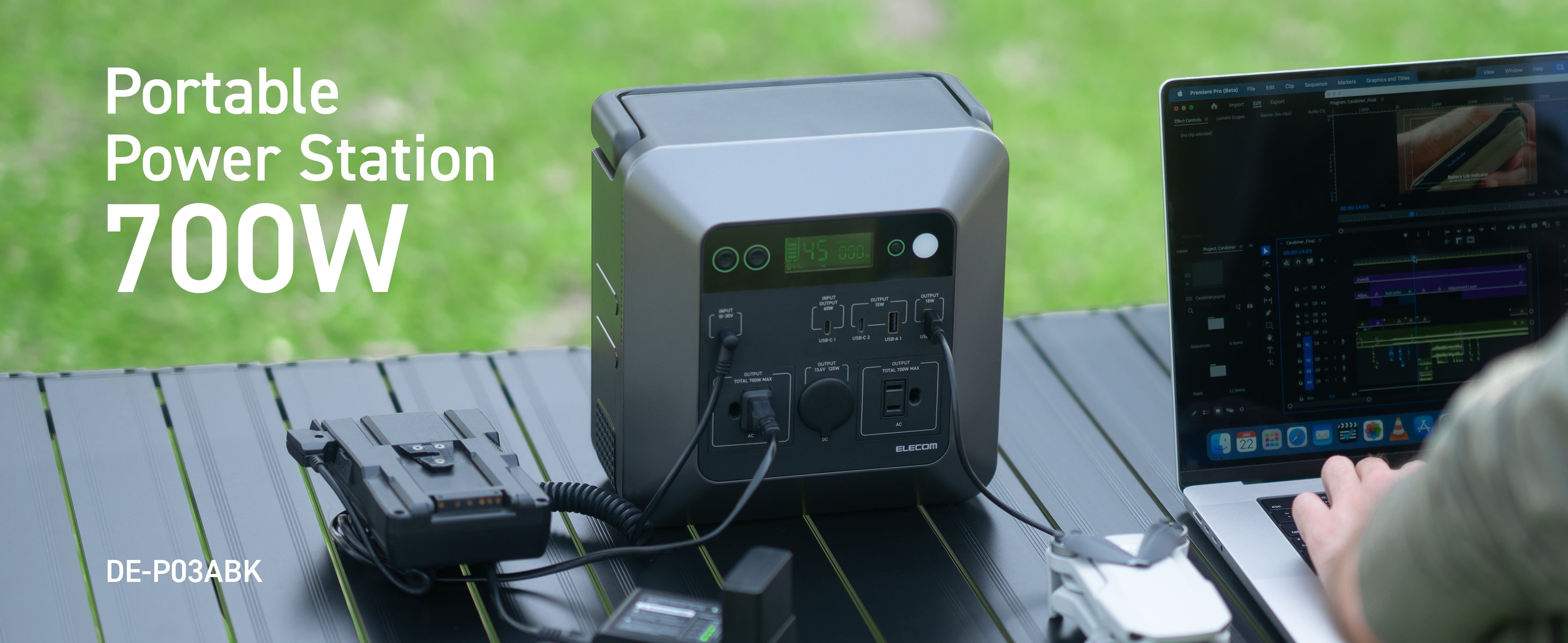 Image of a grey portable power station being used with a macbook pro on an outdoor table | text overlay reads: portable power station 700W | DE-P03ABK