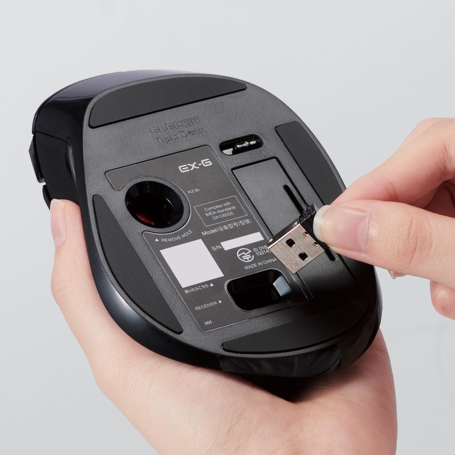 Hands storing USB receiver under mouse | Left-Handed Wireless Trackball Mouse