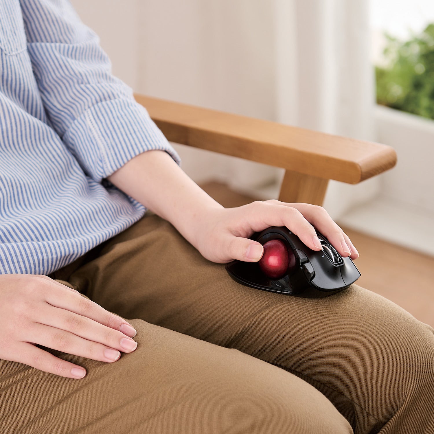 Left-handed person resting trackball mouse on thigh | Left-Handed Wireless Trackball Mouse